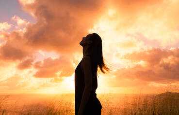 woman standing under sunset